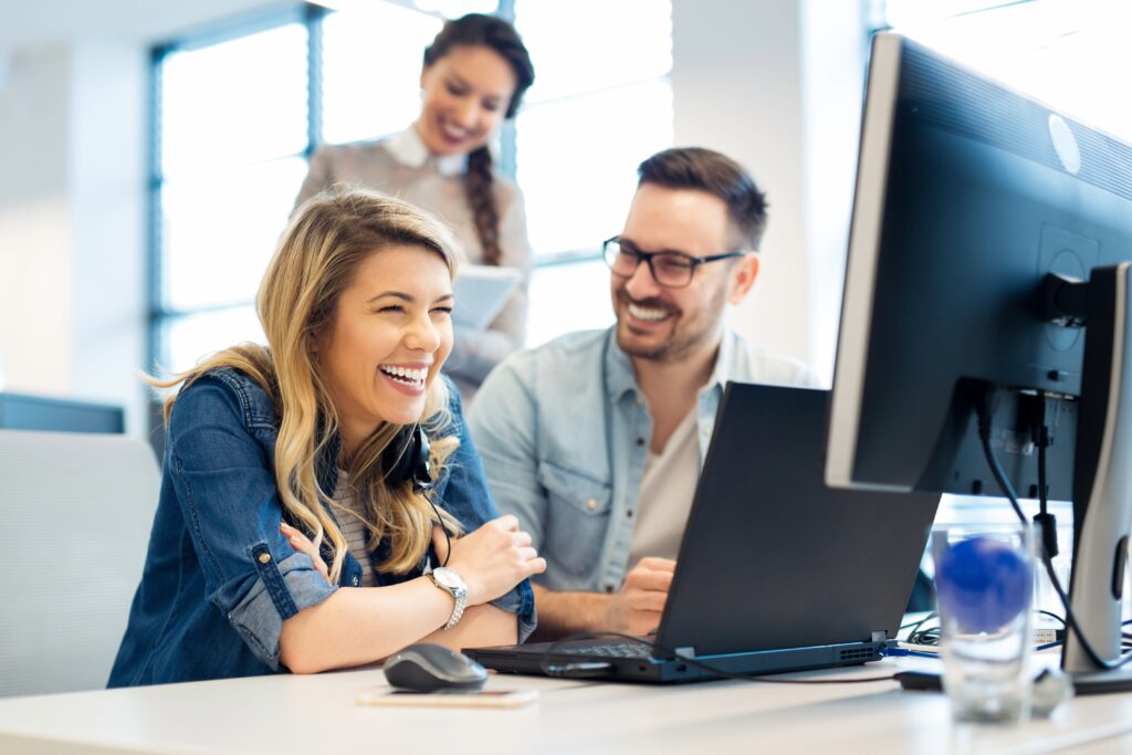 equipo de trabajo alegre frente a computadora